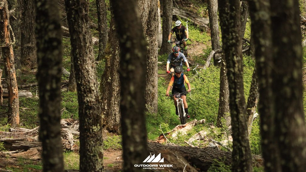 Ciclistas participando en la competencia de mountainbike en los paisajes de Villa Cerro Castillo en la Patagonia